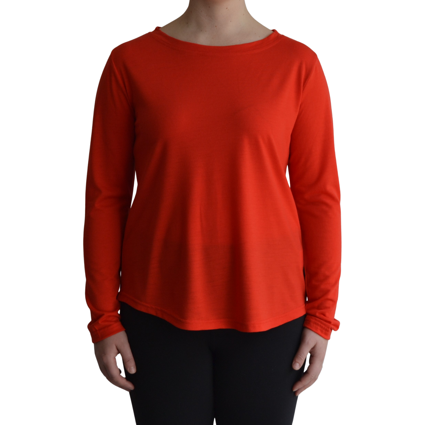 Links long sleeve merino top in mandarin colour, model faces forward showing the front of the top with scooped neck and hemline..