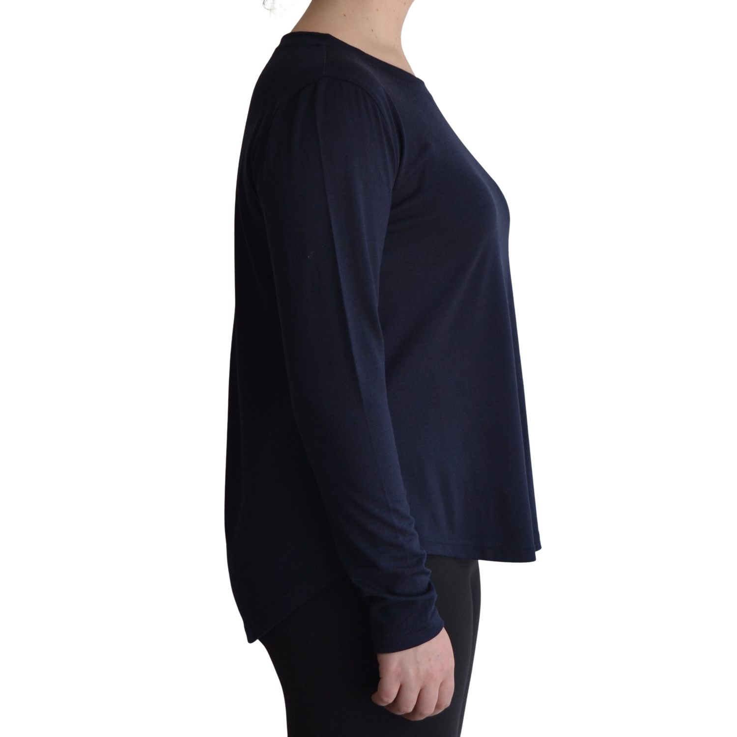 Links long sleeve merino top in navy blue colour, model is standing in profile showing the side view of the shirt with a scooped hemline that drops lower at the back. 